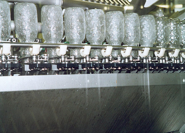 A triple-channel rinser is used to spray the inside of each bottle with paracetic acid, sterile water, and sterile air.