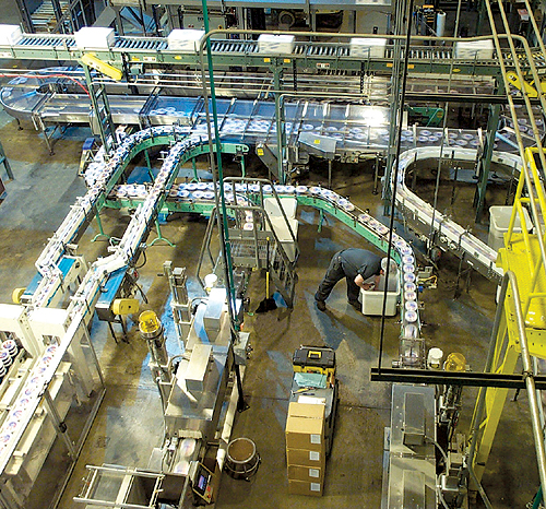 In this birds-eye view at Peak Foods, bowls are conveyed from parallel shrink banders at the bottom to the accumulation table at