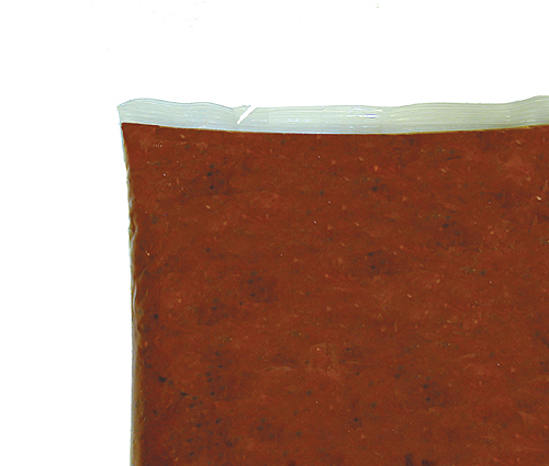 Paradise Tomato Kitchens has added an easy-opening tear notch (top) to its foodservice pouches.