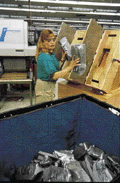 The hardened corner cushions are taken from the molds and placed in plastic bins to be used as needed by the packagers