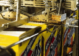 Boxes of Sunlight laundry detergent, conveying upside down, are bottom-sealed (above) after scoop dropping and filling. At the p