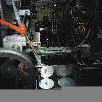 Vacuum arms pick two separate pieces of corrugated from a magazine and position them on opposite sides of the center can to serv