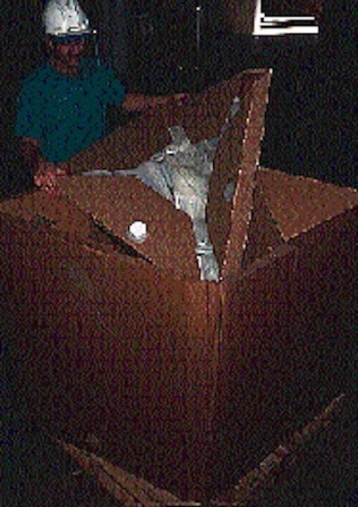 Once the sides of the container are raised, the operator inserts the bag cassette into the box (right). The fitting on the bag