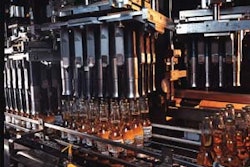 As a group of bottles is conveyed right to left in the case packer, one of the eight heads of gripping bells moves into position