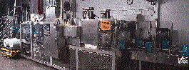 One key to wrapping six somewhat unstable lightweight bottles is a movable bridge that transports the bottle group as they?