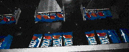 Bars discharge from the wrapper six at a time, with three continuing on one right-angled conveyor (above), three on another. Aft