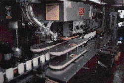 After discharging from the liquid nitrogen chiller, deodorant containers index to this capper for application of polypropylene c