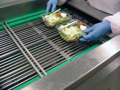 HANDY PACKAGING. An operator places prepared salads in rPET containers two-up at the infeed (above) of the Hera MAP system, also