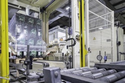 Conveyor transports the stacks to the packaging system, where a film hood is pulled over the palletized beverage cases.