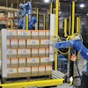 ROBOTIC APPLICATION. Protective corrugated cornerboards are applied automatically by this robotic system just before stretch wrap is applied to the pallet.