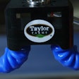 The soft polymer gripper is patterned so that when air fills the channels inside, the fingers wrap around and grip objects.