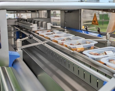 Shown are filled trays entering the SEALPAC A6 tray sealer.