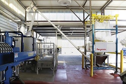Diatomaceous earth moves froth bulk bag through the hopper, flexible screw conveyor and downspout to a 300 gal. before filtration of the wine. The enclosed system eliminates dust and reduces costs from manual dumping of bags. Photo courtesy of Flexicon