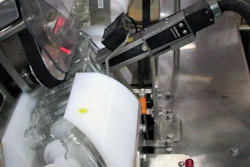 Paired timing screws partially invert bottles so their bottoms can be imprinted by the CIJ coder.
