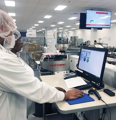 Sovensky Preston (front) and Janice Jackson (rear) analyze OEE data on Packaging Line 2 at Pharmavite in Opelika, Alabama.