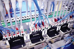 Four robotic end effectors on the cartoner efficiently place finished capsules into waiting cartons.