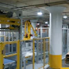 A robotic bag palletizer creates perfectly uniform stacks of bags on a pallet, which then receives a stretch hood.
