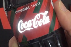 Printed electronics technology causes the Coca-Cola logo to light up at the touch of the hand.