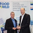 Royal Cup Coffee and Tea’s CEO Bill Smith III and Senior Vice President of Operations Kevin Boughner received their Manufacturing Innovation Award trophy at ProFood Tech 2019. Photo by Kyle Bethea.