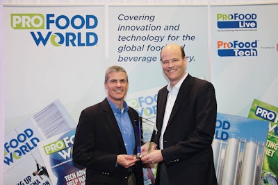 Royal Cup Coffee and Tea’s CEO Bill Smith III and Senior Vice President of Operations Kevin Boughner received their Manufacturing Innovation Award trophy at ProFood Tech 2019. Photo by Kyle Bethea.