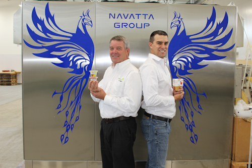 Initiative Foods President John Ypma, left, and VP of Operations James Ypma proudly display their new custom plastic baby food cups while standing in front of new Navatta processing equipment painted with a phoenix to celebrate their business’s rebirth after the fire.