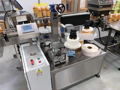This machine applies a wraparound, pressure-sensitive, paper-plus-matte finish label.