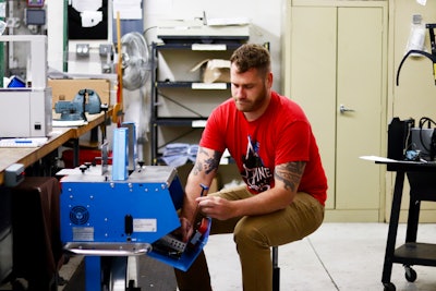 Field Service Engineer, Tony Vorpahl, works on a banding machine. The Felins service team offers a wide range of services for their customers including repairs, service visits, technical support, and customer training.