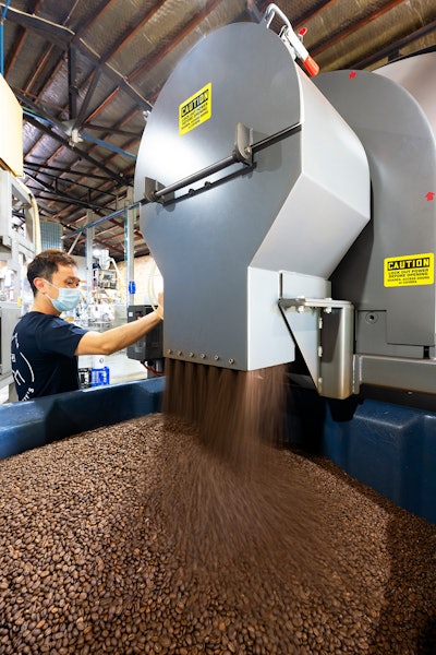 In this rotary batch mixer at Pablo & Rusty’s Coffee Roasters, internal flights direct beans toward and through a stationary discharge as the vessel rotates until fully evacuated.