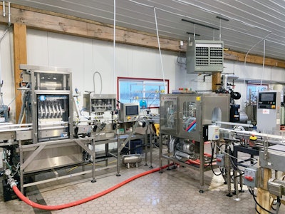 Downstream of the filler and seamer is a rinser, enclosed can dryer, and checkweigher prior to accumulation and tray packing downstream.