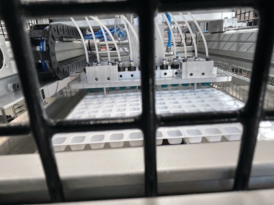 On a mechanical arm, 12 tube-fed sponges swab food-grade anti-sticking agent into each individual cavity of the thermoformed tray, preventing taffy from sticking and allowing it to better hold its shape.