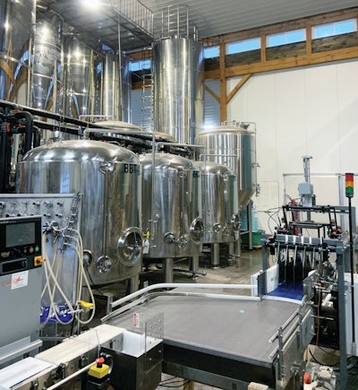 Four lanes of filled cans enter the tray packer from the accumulation table. All sections of the line were assembled in-house.