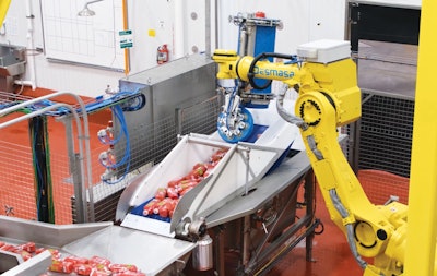 After HPP processing, a robot unloads the juice bottles onto a drying shaker table.