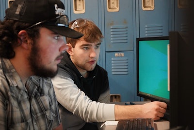 Cody Byrd, mechanical engineer at Hoosier Feeder Company, working with a student.