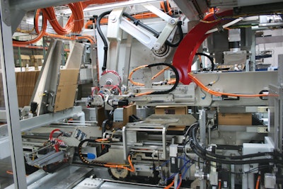 The machine features a case feed robot inside to move flat corrugated blanks into the case erecting segment.