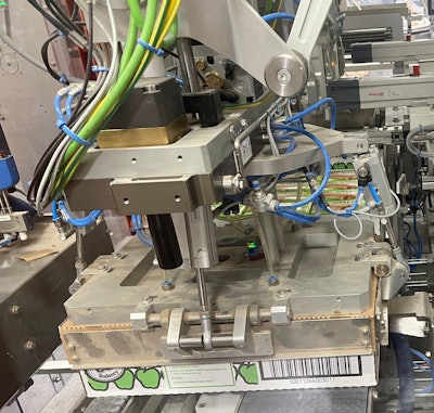 Shown here is the end-of-arm tooling that closes and compresses a corrugated lid onto the 48-count corrugated tray of cartoned pies.