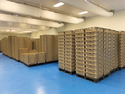 Bags of the woodchip growth medium inoculated with mycelium cells sit in baskets on pallets to grow before being moved to the vertical farm.
