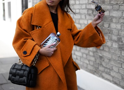 The flask-like bottle features a flat, ergonomic shape that enables it to fit easily into small spaces such as crossbody bags, back pockets, and seat-back storage on trains and planes.