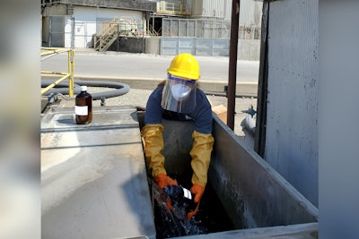 Laura Hubbard collecting treated wastewater samples at a food processing facility.