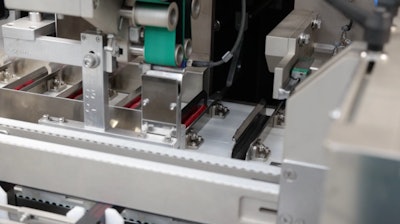 The green belt shoots the literature or pamphlet in between the carton and the mascara tube. When tubes are pushed into the carton, the literature goes along for the ride.