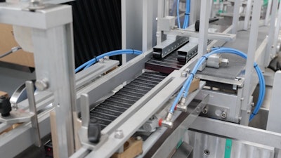 The first layer of 24 cartoned mascara tubes drops to make room the second layer. Once the 10th layer is added, a 240-ct cubic block is formed.