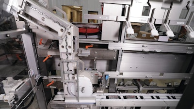 A track-and-gravity feed station (left) guides batteries downward vertically so that a star wheel can present whatever number of batteries is required for the carton being produced—in this case it’s eight—and send those batteries off horizontally to the next operation.