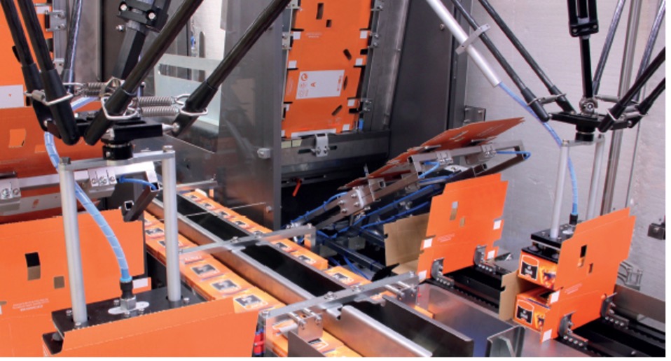 Automated robotic packaging machine with orange panels and mechanical arms