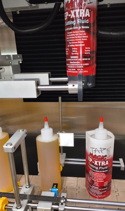 16-oz HDPE bottle in productionat Tap Magic: Application of a shrink sleeve on the Sleeve Seal machine.