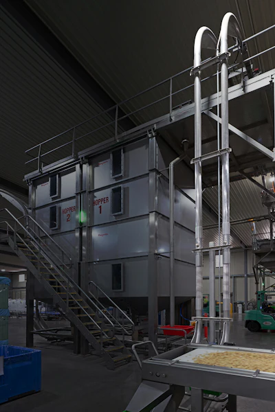 This FLEXI-DISC tubular cable conveyor system climbs horizontally more than 12 meters to reach the top of the twin storage hoppers servicing slicing and packaging operations.
