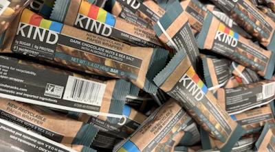 Stack of KIND dark chocolate almond sea salt snack bars with branded packaging and nutritional labels