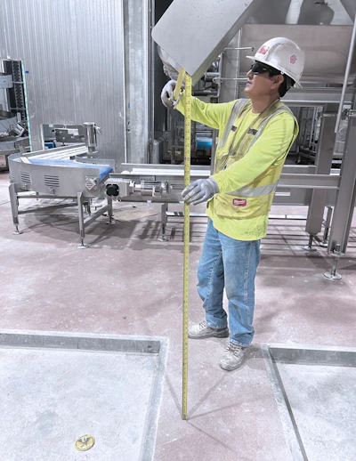 A ProFab technician measures during installation preparation.