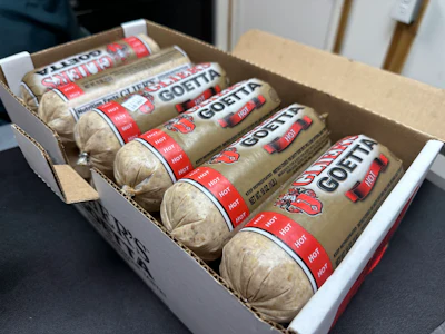 Box of Goetta hot sausage packages with red and white labeling arranged in cardboard shipping container