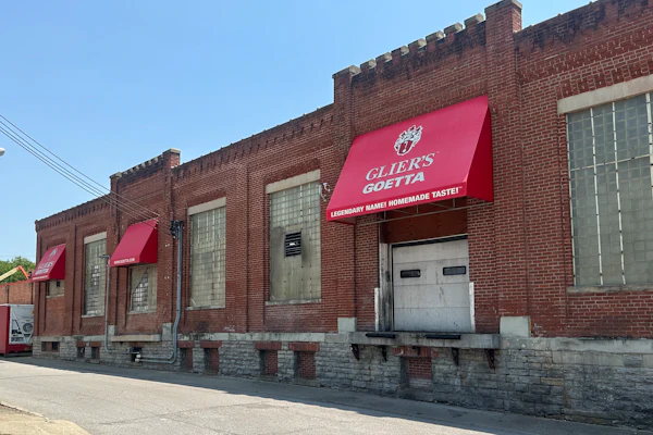 Historic brick storefront with red awnings displaying Guida's Guetta branding and 'Everybody Makes Homemade Taste' tagline