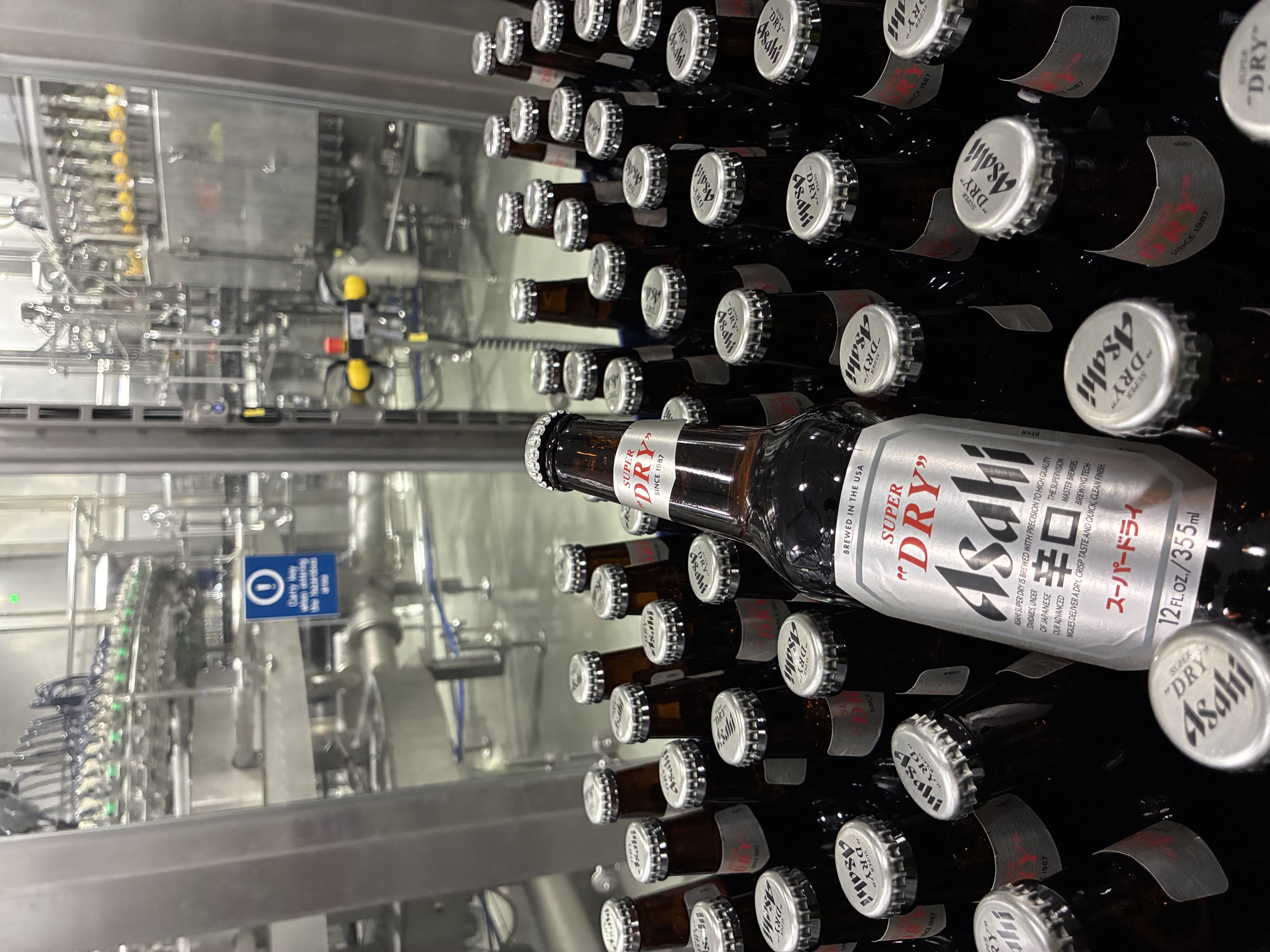 Both 12-oz (shown) and 21-oz bottles are filled on the line, and body labels in both cases promote the “Brewed in the USA” message.