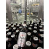 Both 12-oz (shown) and 21-oz bottles are filled on the line, and body labels in both cases promote the “Brewed in the USA” message.